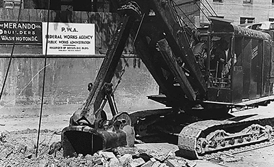A large piece of construction equipment digs into concrete